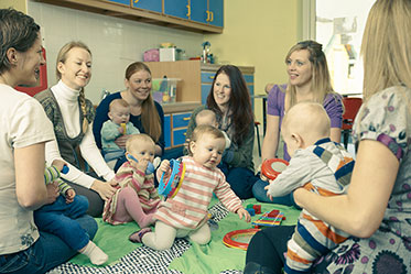 Vergrößerungsansichten für Bild: Gruppenfoto: Mütter sitzen mit ihren Babys in einem Kreis zusammen.